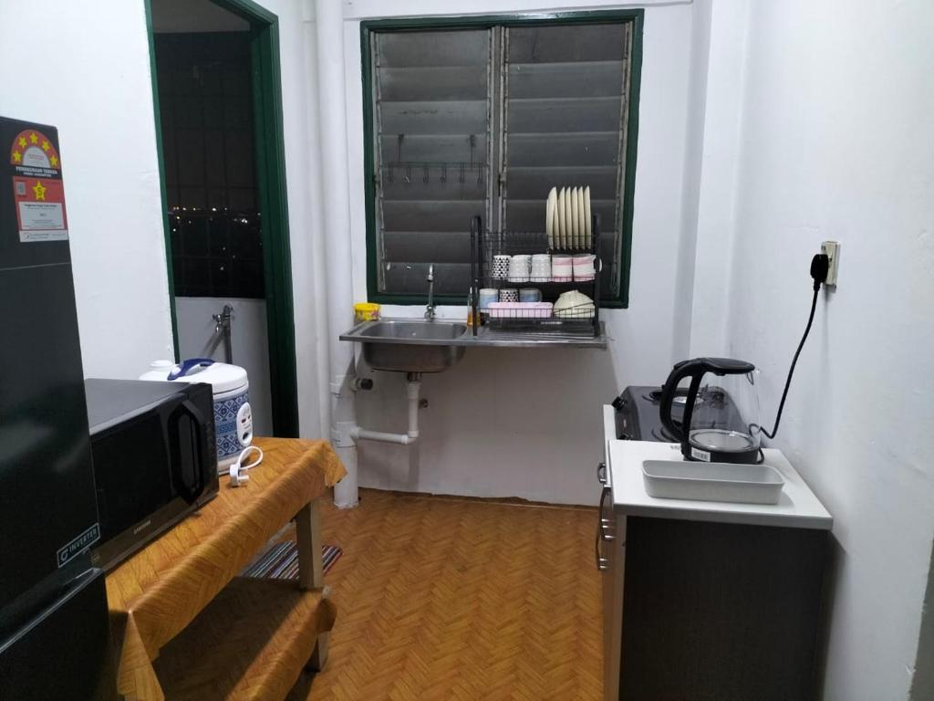 Cette petite chambre dispose d'un lavabo et d'une fenêtre. dans l'établissement KHAIRUL HOMESTAY PANGSAPURI SUTERA SEBERANG JAYA, à Kampong Telok