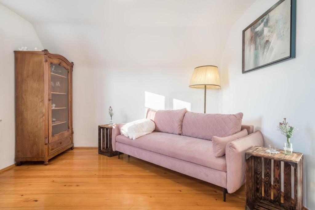 a living room with a pink couch and a dresser at Thurnher in Dornbirn