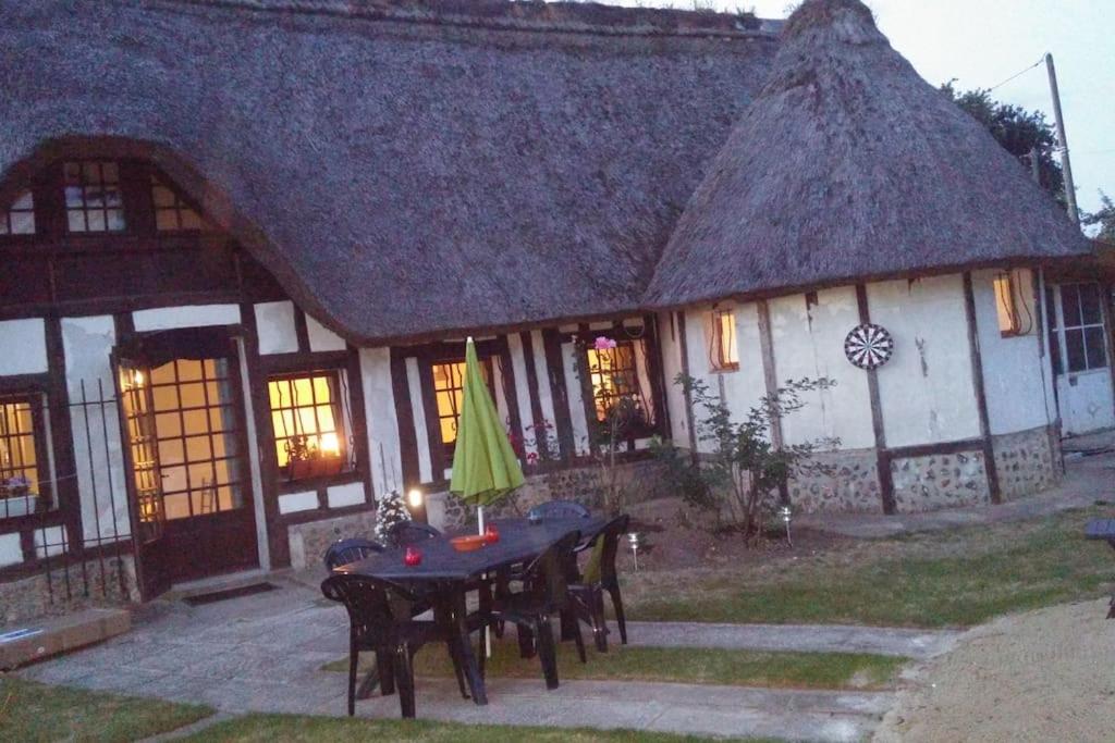une maison avec une table et des chaises devant dans l'établissement La tourelle de la chaumière, à Goupillières