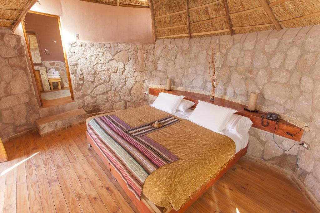 A bed or beds in a room at Ckamur Atacama Ethno Lodge & Spa