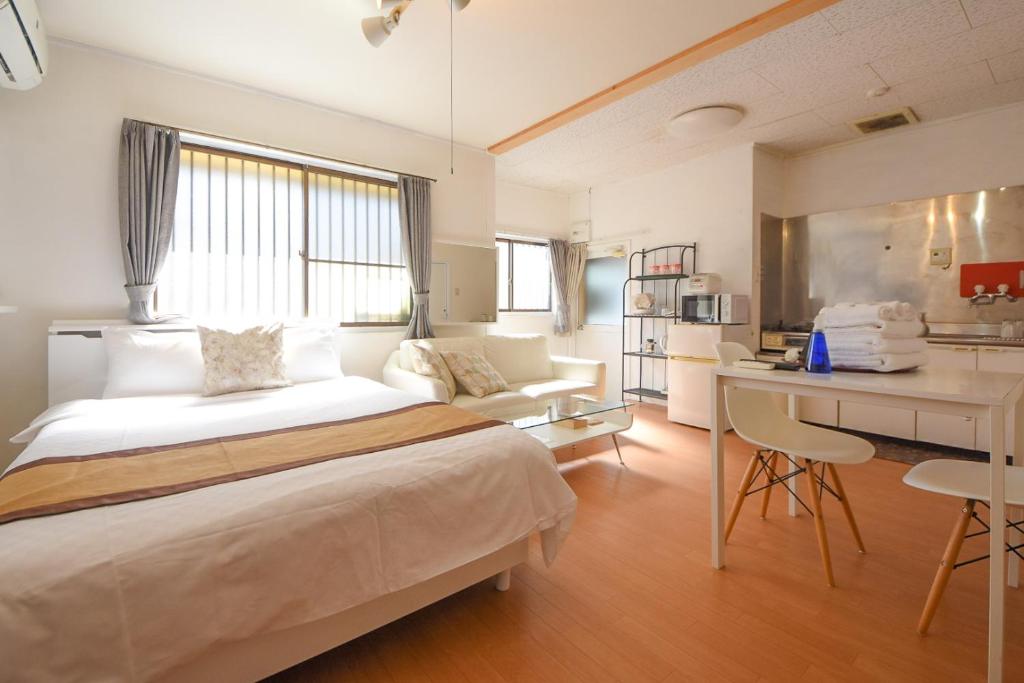 1 dormitorio con cama, escritorio y cocina en Estancia Cómoda MR1&MR2, en Nara