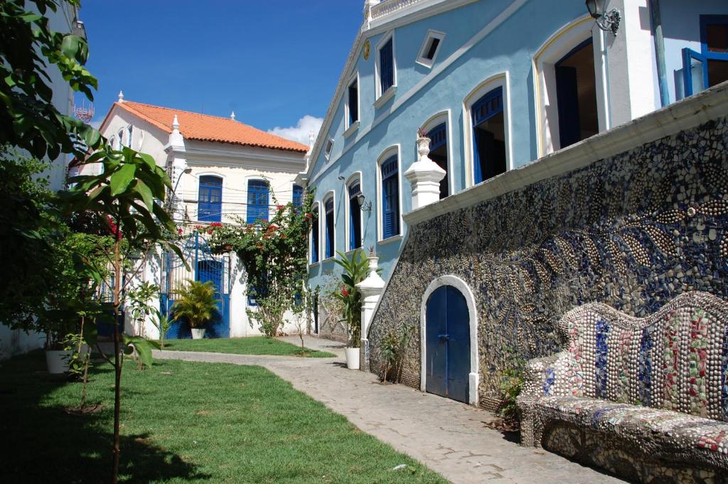 um edifício azul e branco com um banco à frente em Pousada Barroco na Bahia em Salvador