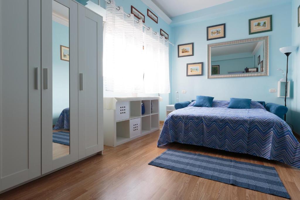 ローマにあるSimon Holiday Houseの青い壁のベッドルーム(ベッド1台、鏡付)