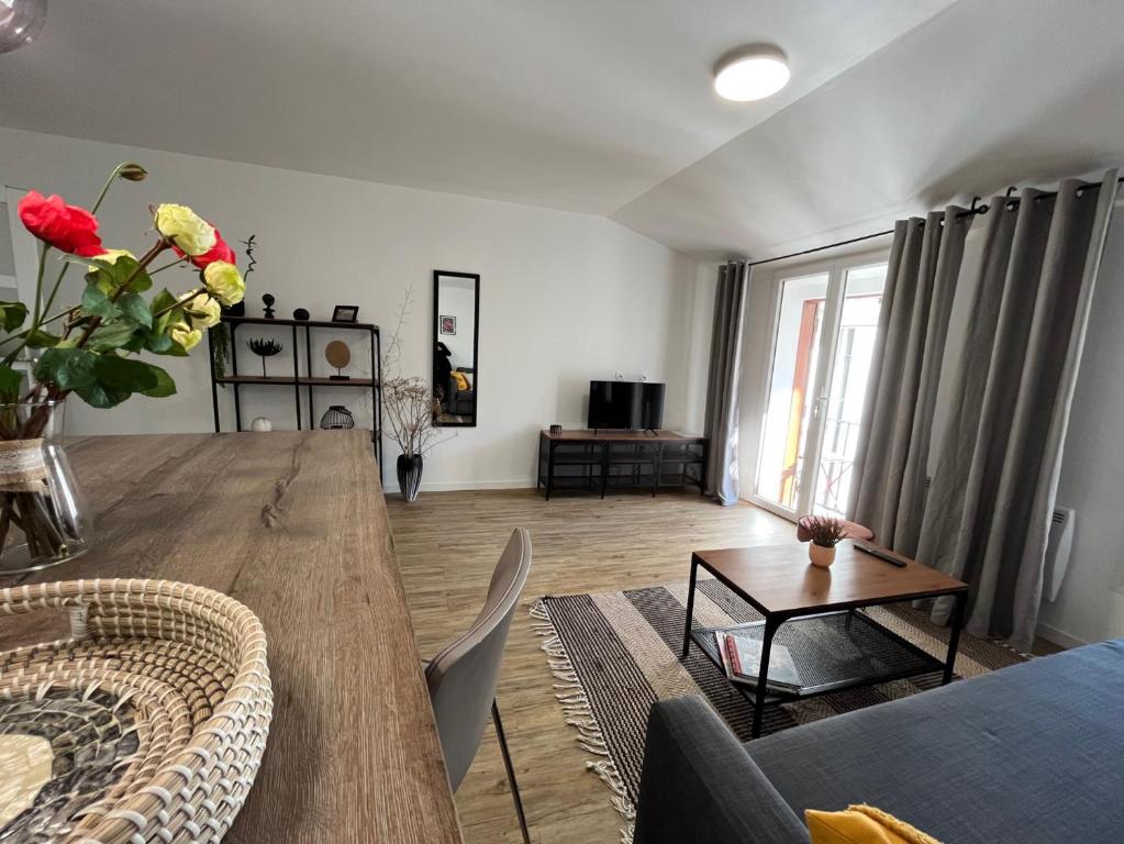- un salon avec une grande table en bois et un canapé dans l'établissement Style et ambiance, à Foix