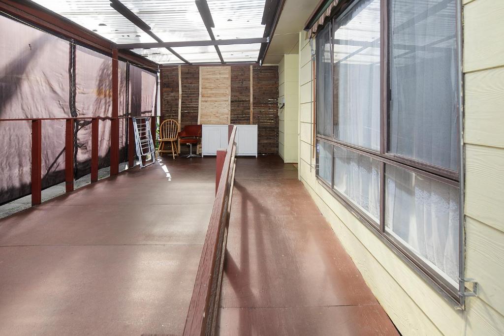 um corredor vazio com janelas, uma mesa e cadeiras em Melbourne Guest house em Doveton