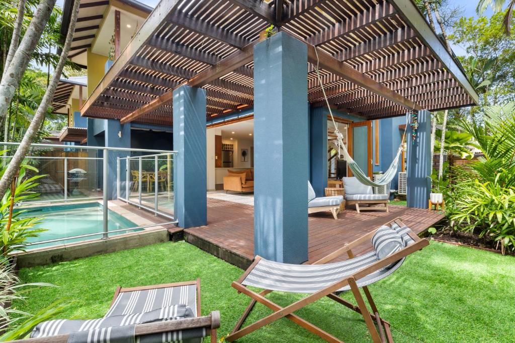 a backyard with a swing and a house at The Savannah Villa in Port Douglas