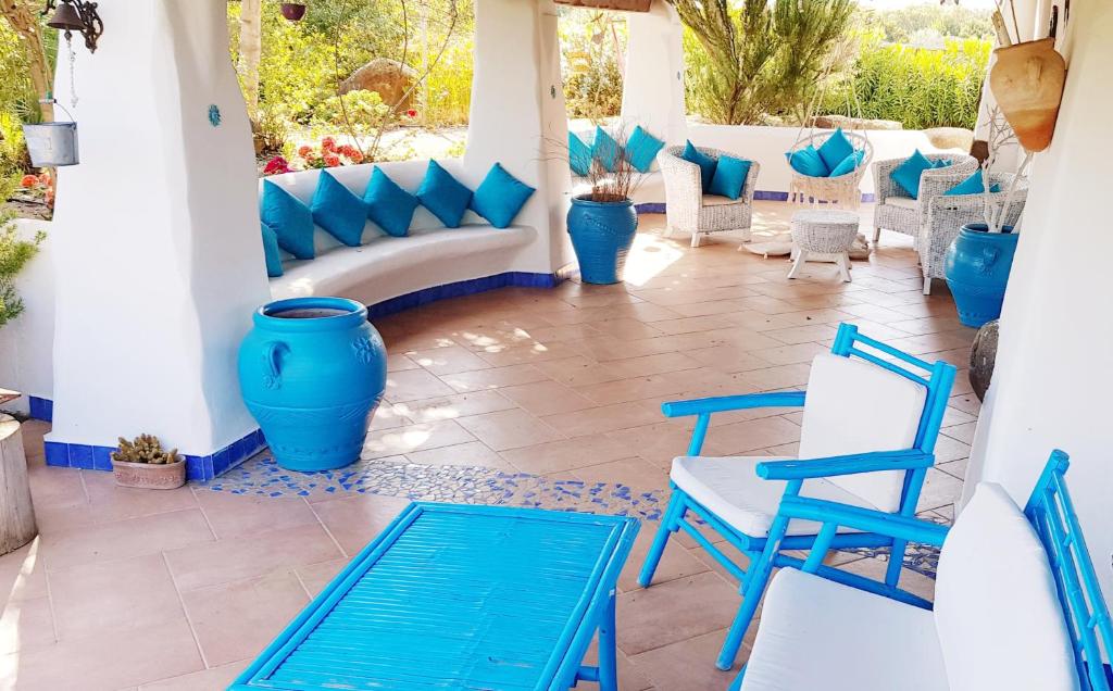 un patio con sedie blu e sedie blu di La Casa dell'Artista a Orosei