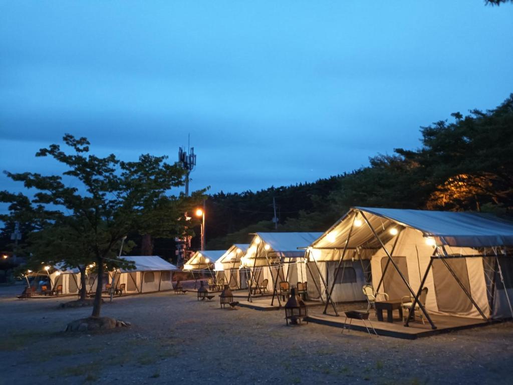 een rij tenten op een parkeerplaats 's nachts bij Club Lespia in Taean in Taean