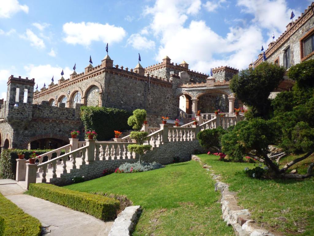 un antiguo edificio con una valla blanca y un patio en Hotel Castillo de Santa Cecilia, en Guanajuato