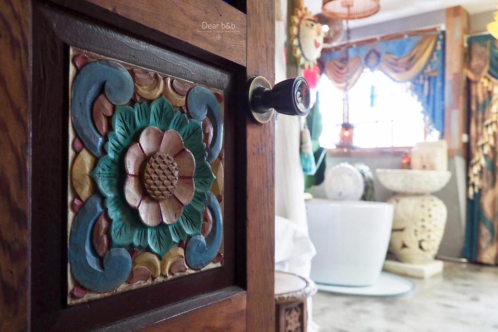 a wooden door with a flower painted on it at Fas BnB in Jiali
