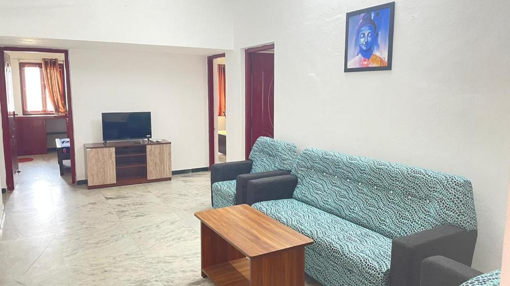 uma sala de estar com um sofá e uma televisão em WHITE HOUSE - 3BHK Elegant Apartment em Coimbatore