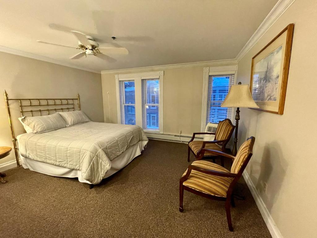 ein Schlafzimmer mit einem Bett und einem Stuhl sowie zwei Fenstern in der Unterkunft Condo at The Park Hotel in Park City