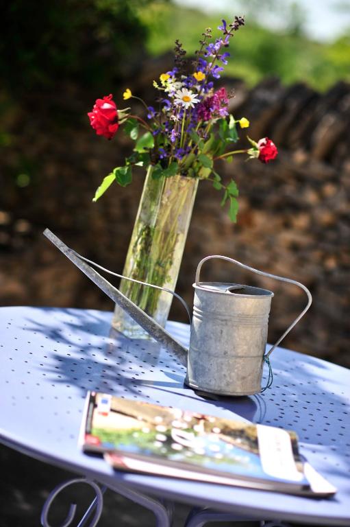 a vase of flowers and a candle on a table at Domaine Lagardelle Rocamadour in Rocamadour