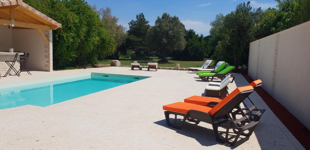 a patio with chairs and a swimming pool at MAS TAREAU LE DAMIER in Beaucaire
