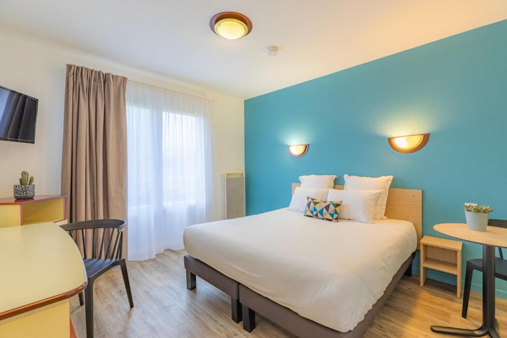 una camera d'albergo con letto e tavolo di Appart'City Classic Caen a Caen
