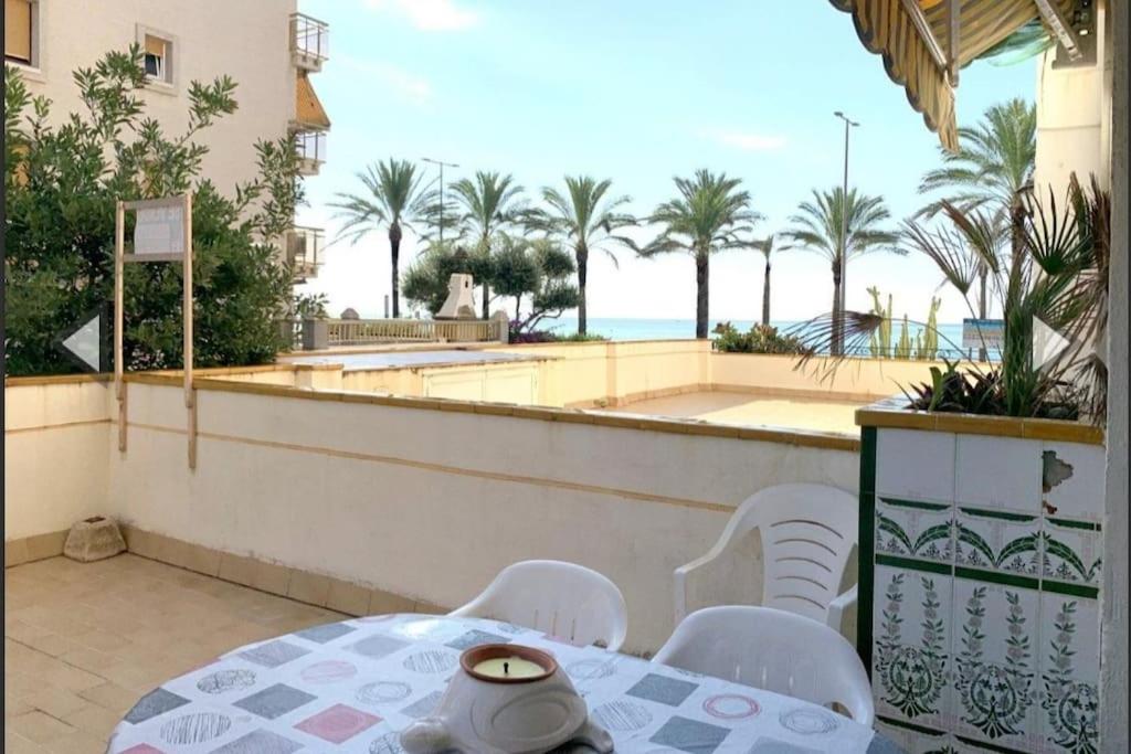 uma mesa e cadeiras numa varanda com vista para a praia em Apartamento con terraza en 1ª linea lateral a mar em Calafell