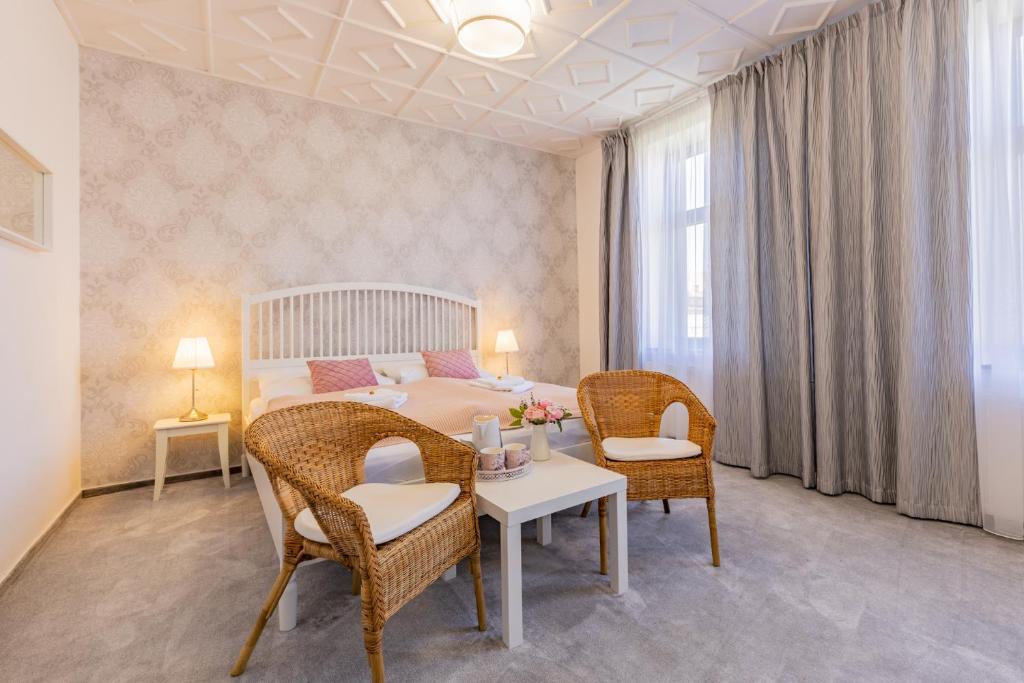 Hotel Amadeus في تشيسكي بوديوفيتسه: غرفة نوم بسرير وطاولة وكراسي