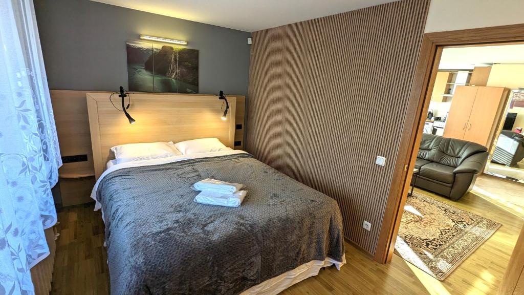 a bedroom with a bed with two towels on it at HYGGE Apartment CONTACTLESS CHECK-IN in Šiauliai