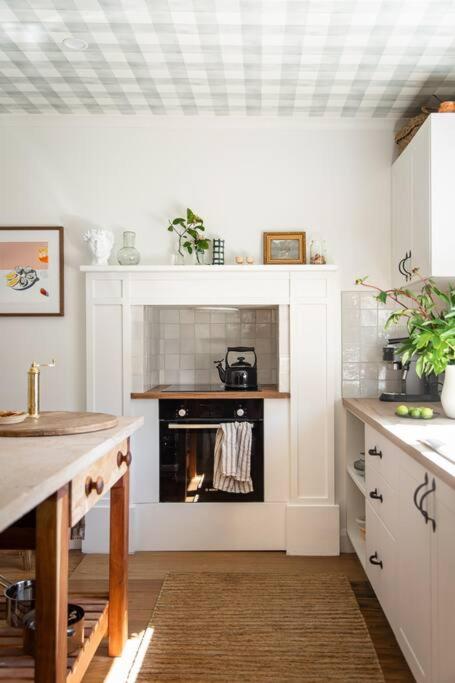 cocina con chimenea en el medio de una habitación en Millingtons House, en Orford