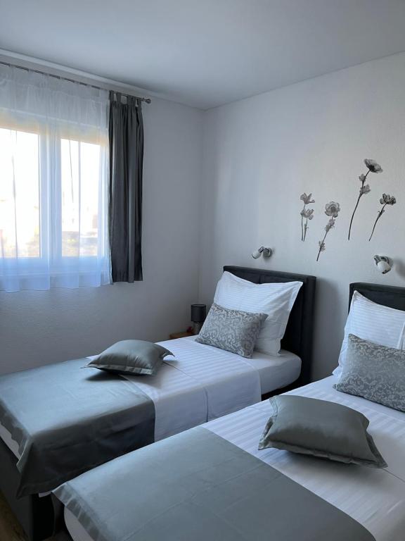 zwei Betten stehen nebeneinander in einem Schlafzimmer in der Unterkunft Apartments Magdalena in Stobreč