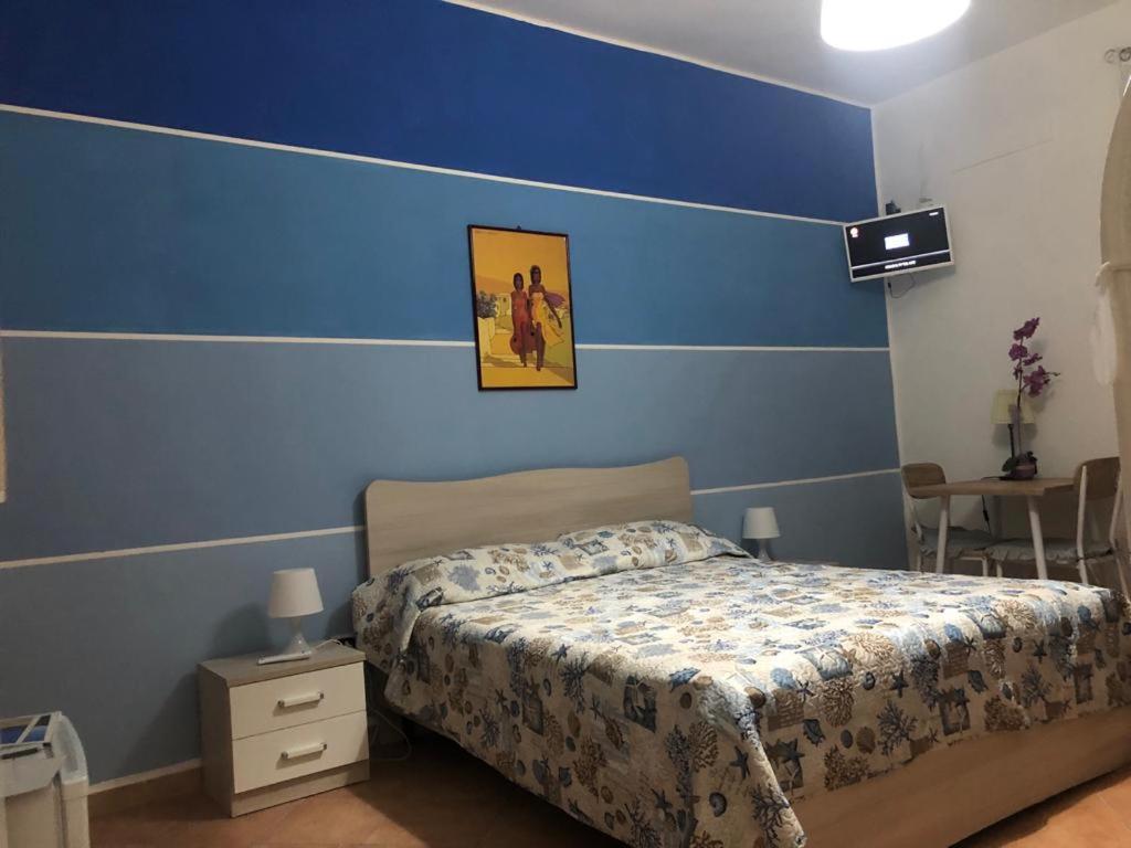 - une chambre avec un lit et un mur bleu dans l'établissement La casa dei nonni piano terra, à Montallegro