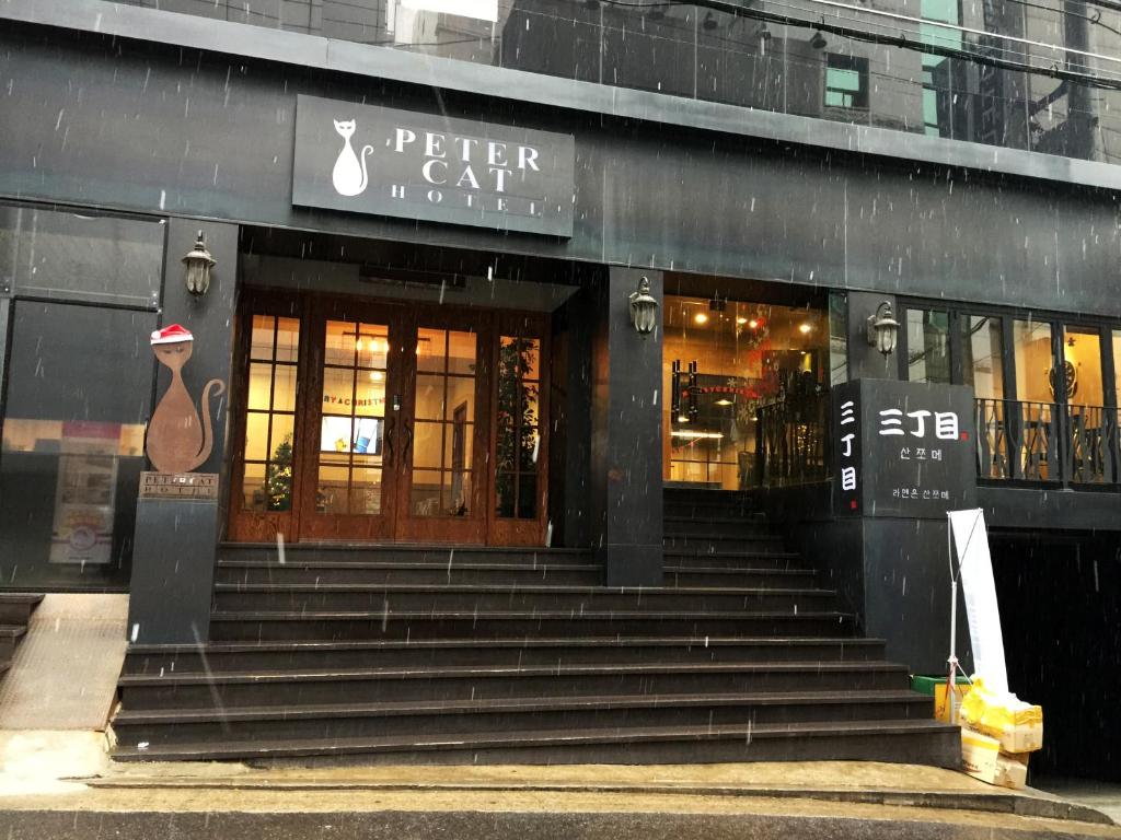 ein Geschäft vor einem Gebäude mit einer Treppe davor in der Unterkunft Petercat Hotel Shinchon in Seoul