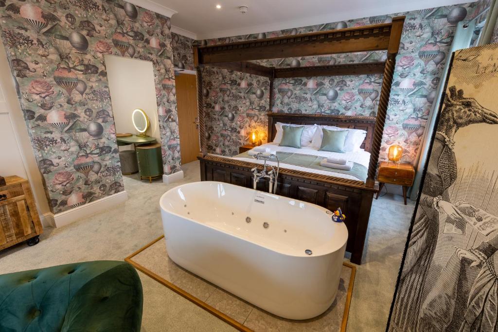 The Resolution Hotel في ويتبي: غرفة نوم مع حوض استحمام وسرير
