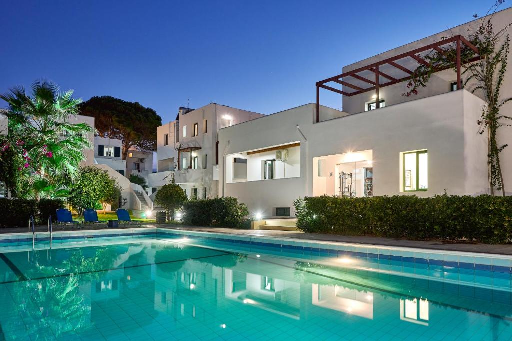 - une piscine en face d'une maison la nuit dans l'établissement Eva Suites & Apartments, à Agia Marina