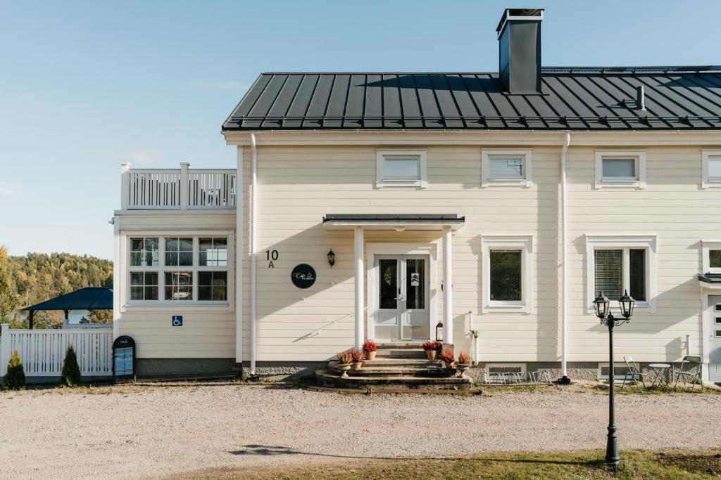 une maison blanche avec un toit noir dans l'établissement Boutique Hotel Villa Klubiranta, à Halli