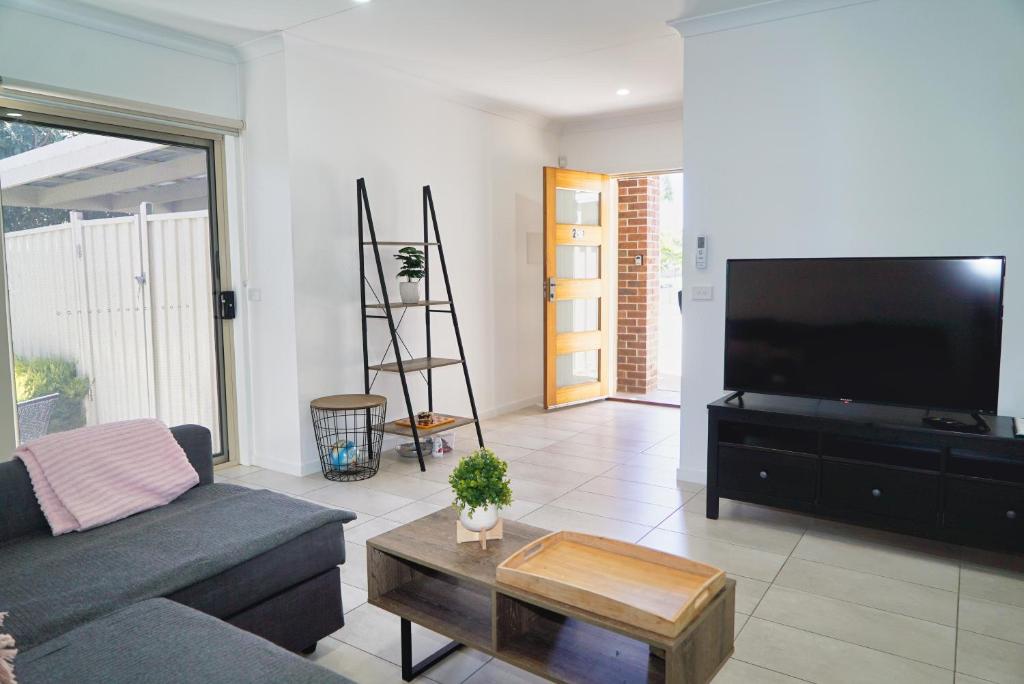 a living room with a couch and a flat screen tv at Modern style unit 2 Deer Park in Deer Park