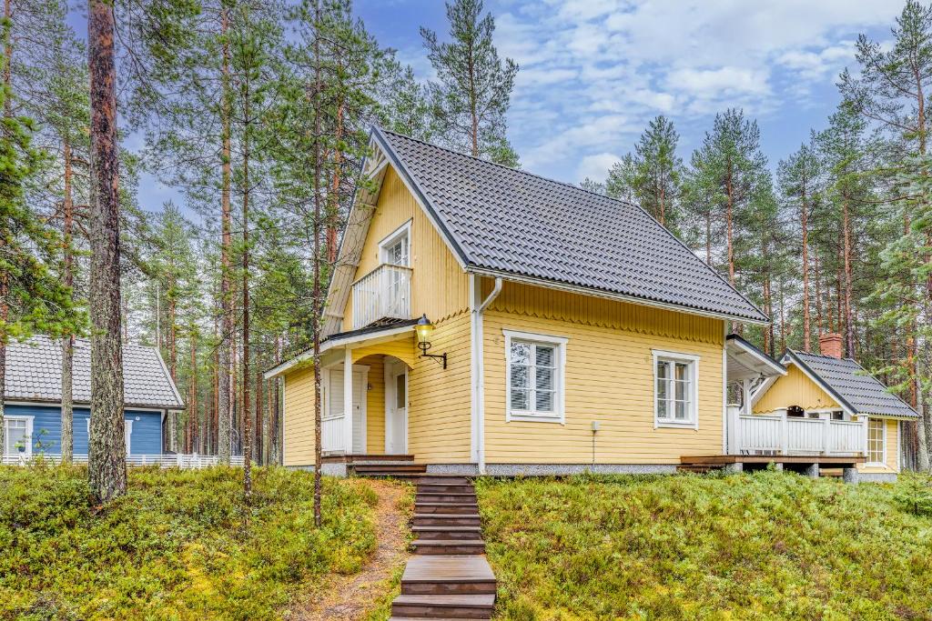 a yellow house in the middle of a forest at Lomamökki Johtojuku 1 in Kalajoki