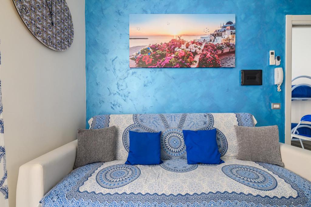 um quarto com paredes azuis e uma cama com almofadas azuis em Appartamento Luci d'Artista em Vietri