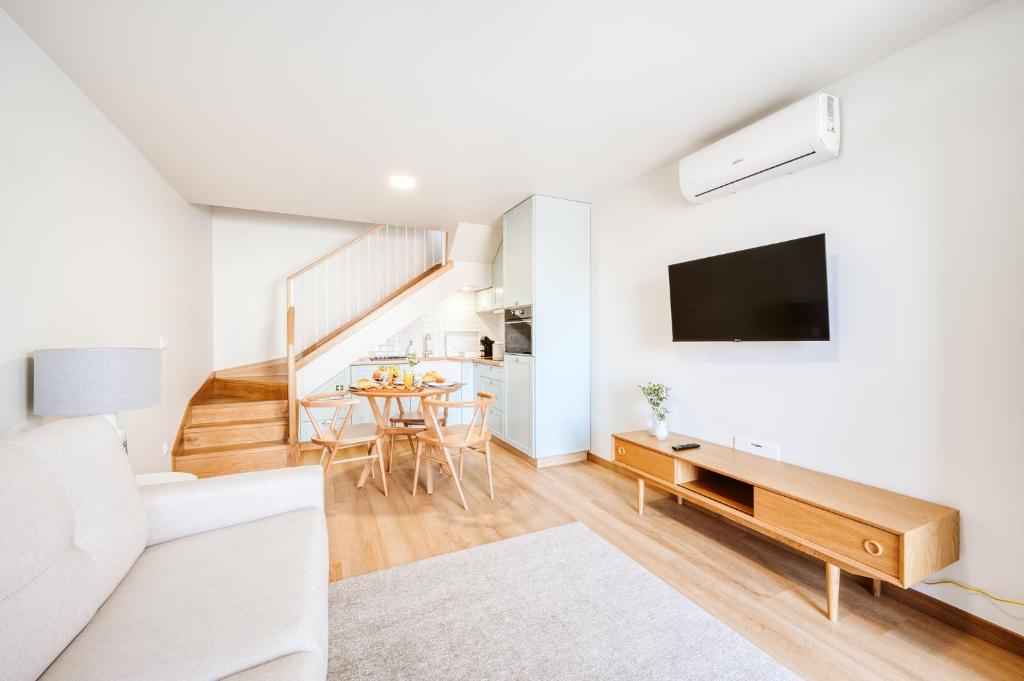 a living room with a couch and a tv on a wall at Casa das Andorinhas - 1 bedroom apartment sleeps 4 in Câmara de Lobos