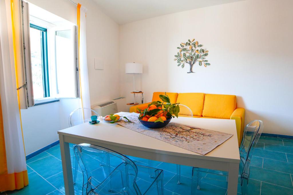 uma sala de estar com uma mesa e um sofá amarelo em Ncopp' a' Scalinatella em Scala