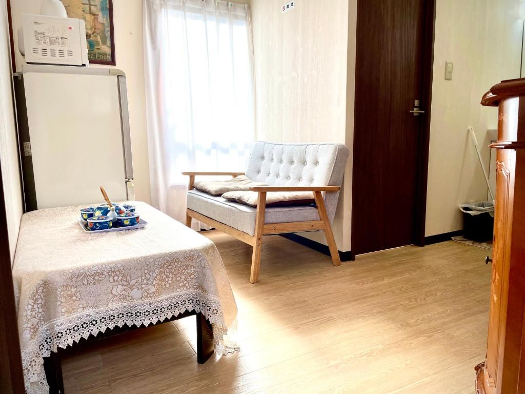 uma sala de estar com uma cadeira e uma mesa em 新宿直通完全貸切一軒家 em Tóquio