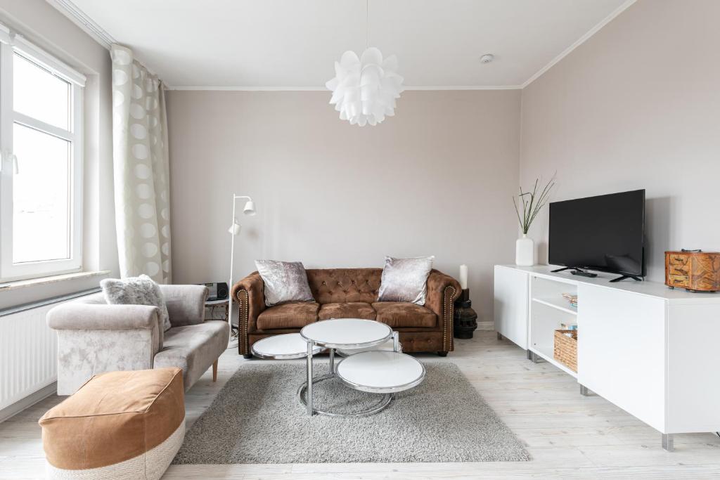 ein Wohnzimmer mit einem Sofa und einem TV in der Unterkunft Haus MeerZeit Whg.2 in Cuxhaven