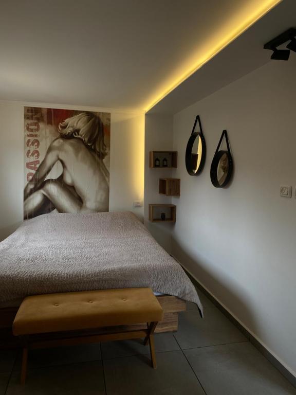 1 dormitorio con 1 cama y una pintura en la pared en צימר המסה, en Mas'ada