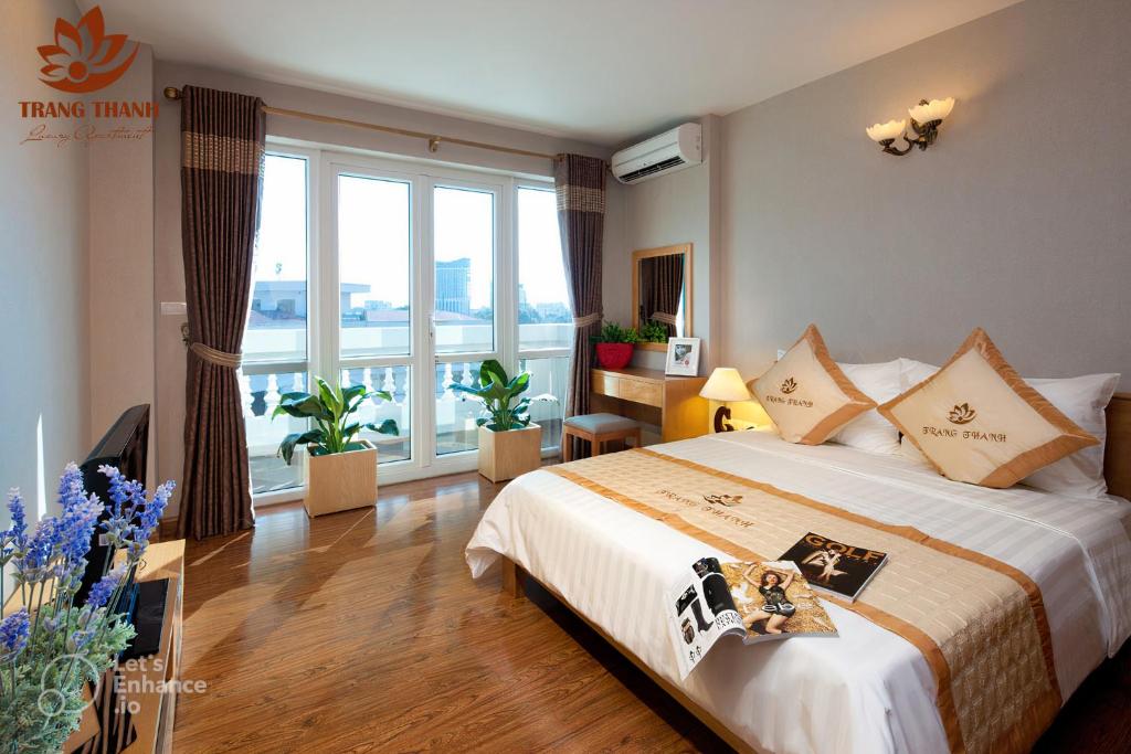 a hotel room with a bed and a large window at Trang Thanh Luxury Apartment in Hai Phong