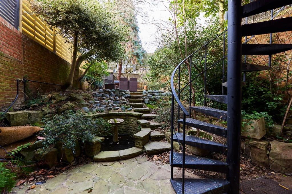 een trap naar een tuin met een stenen pad bij The Bayswater Nook - Stylish 1BDR Flat in Londen