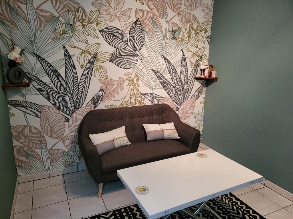 ein Wohnzimmer mit einem Sofa und einem Tisch in der Unterkunft Gîte Santenay les Bains in Saint-Sernin-du-Plain