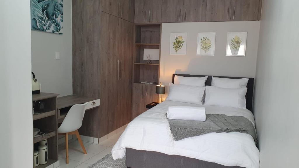 1 dormitorio con cama, escritorio y silla en Refreshing Space in Eden Glen, Johannesburg, SA en Edenvale