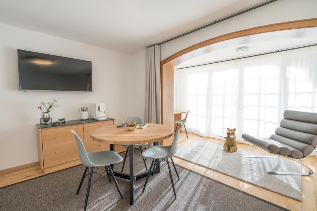 a living room with a wooden table and chairs at Landhaus Wiederkehr in Oberstdorf