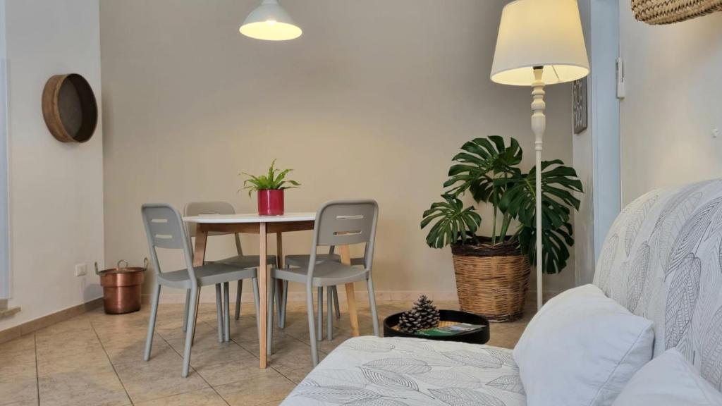 ein Esszimmer mit einem Tisch, Stühlen und einer Pflanze in der Unterkunft La Casa più Bella in Custonaci