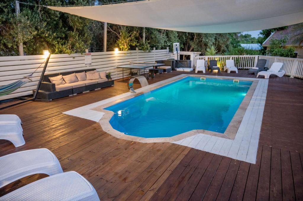 a swimming pool on a deck with chairs and a table at Helios Luxury Caravan's in Had Nes