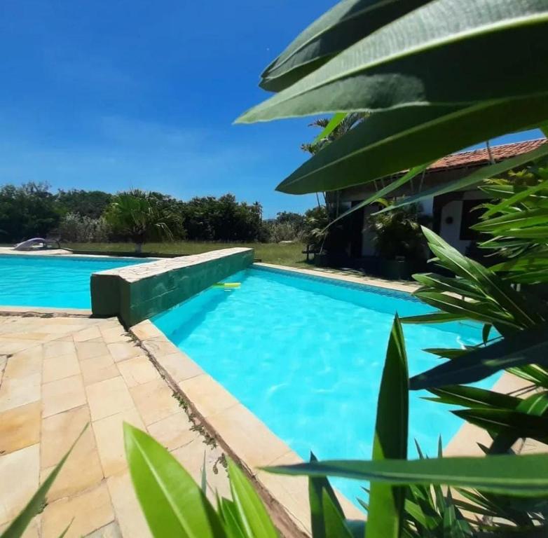 una piscina con agua azul y plantas verdes en POUSADA ARKAN BEACH, en Saquarema