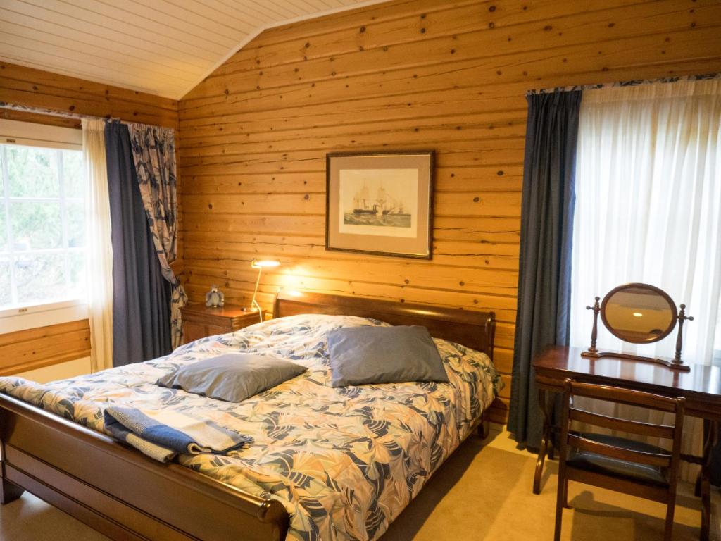 a bedroom with a bed and a wooden wall at Villa Mustikka in Ekenäs
