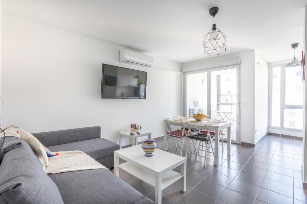 - un salon avec un canapé et une table dans l'établissement NEW JOLIETTE Comfortable Apartment well located with private parking, à Marseille