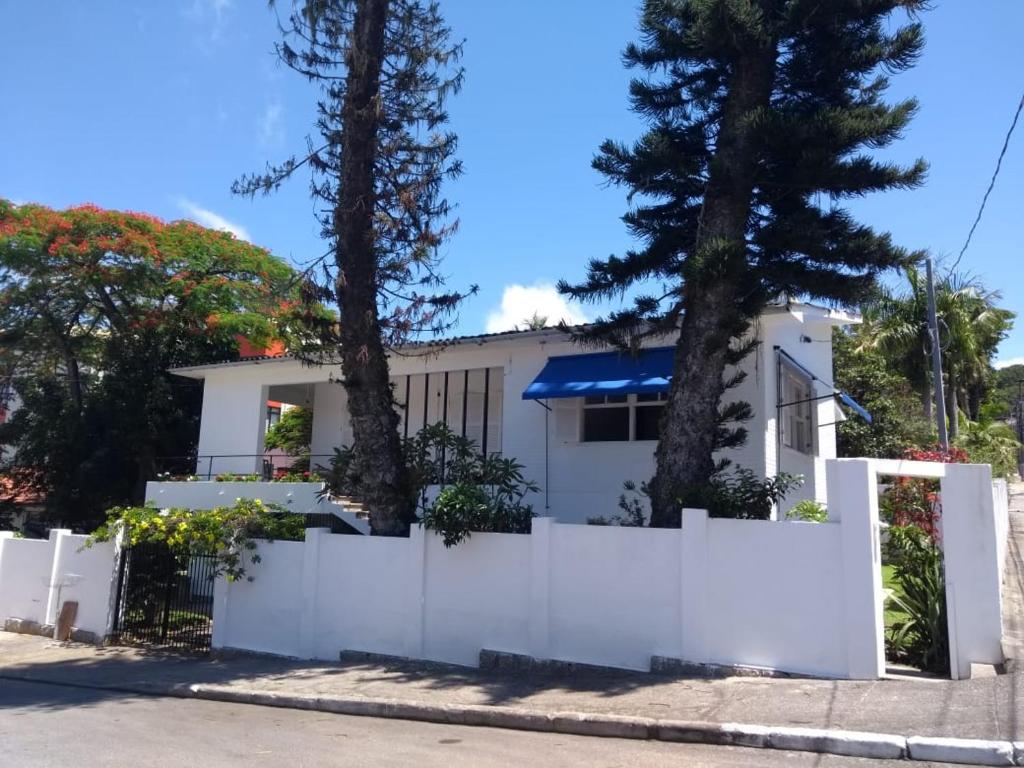 a white house with a white fence and trees at A Primeira Vista in Florianópolis