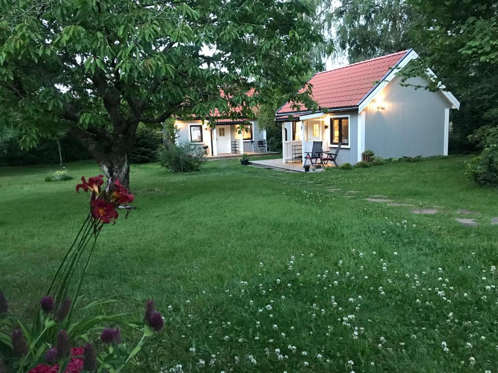 una pequeña casa blanca con un árbol en un patio en TOBSBORG 2 en Simrishamn