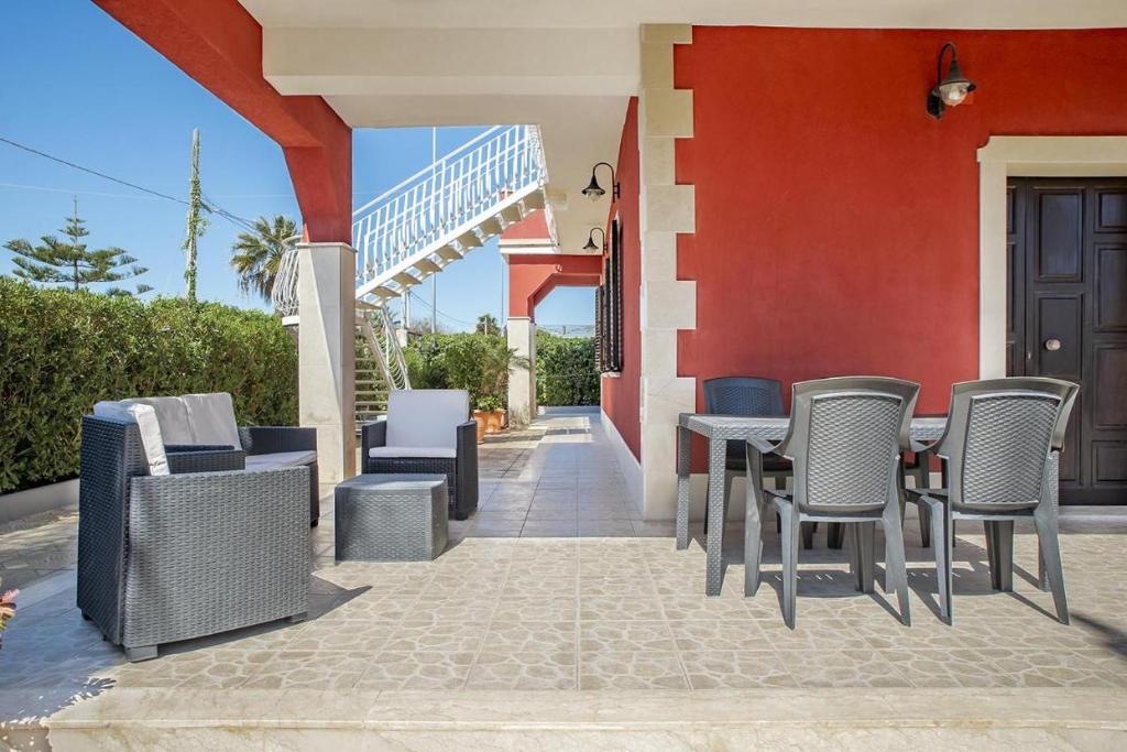 un patio con sillas y mesas y un edificio en Villa Lucia, en Ognina
